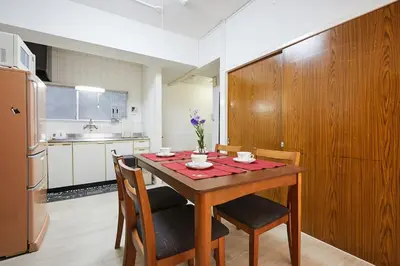 a kitchen with a table with chairs and a refrigerator at G&R House 102 in Tokyo