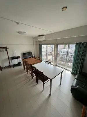 a living room with a table and chairs and a large window at G&R House302 in Tokyo