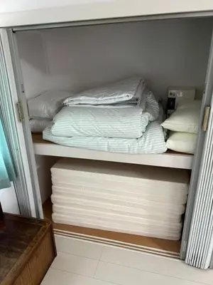 a closet filled with white sheets and pillows at G&R House302 in Tokyo