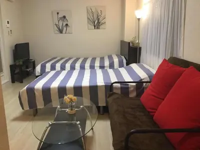 a living room with two beds and a couch at \u99c5\u8fd1-JR\u5c0f\u5ca9\u99c5\u307e\u3067\u5f92\u6b693\u5206-Leo\u5c0f\u5ca9 101 in Tokyo