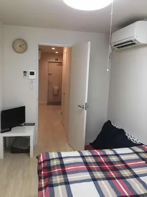a bedroom with a bed and a desk and a clock at \u99c5\u8fd1-JR\u5c0f\u5ca9\u99c5\u307e\u3067\u5f92\u6b693\u5206 Leo\u5c0f\u5ca9203 in Tokyo