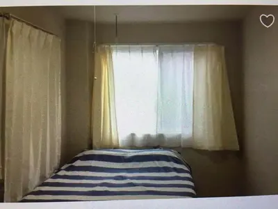 a bedroom with a window and a bed with a striped pillow at \u99c5\u8fd1-JR\u5c0f\u5ca9\u99c5\u307e\u3067\u5f92\u6b693\u5206 Leo\u5c0f\u5ca9203 in Tokyo