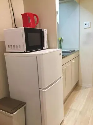 a microwave on top of a refrigerator in a kitchen at \u99c5\u8fd1-JR\u5c0f\u5ca9\u99c5\u307e\u3067\u5f92\u6b693\u5206 Leo\u5c0f\u5ca9203 in Tokyo
