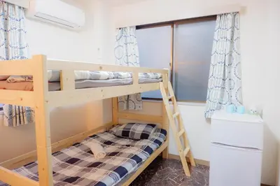 a bunk bed with a ladder in a room at \u532f\u91d1\u6d45\u8349\u4e00\u53f7\u9928 in Tokyo