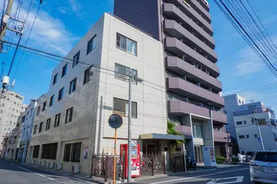 a tall white building on a city street at \u532f\u91d1\u6d45\u8349\u4e00\u53f7\u9928 in Tokyo