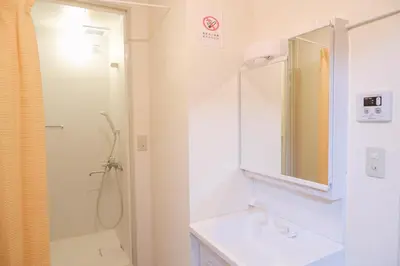 a bathroom with a sink and a shower and a mirror at \u532f\u91d1\u6d45\u8349\u4e00\u53f7\u9928 in Tokyo