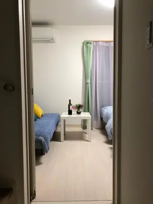 a room with two beds and a table and a window at Takara House in Tokyo