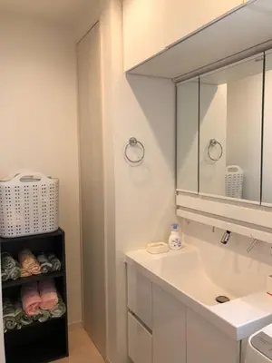 a white bathroom with a sink and a mirror at Takara House in Tokyo