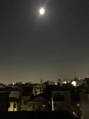 a moon in the sky over a city at night at Takara House in Tokyo