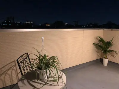 a patio with two plants and a fence at night at Takara House in Tokyo