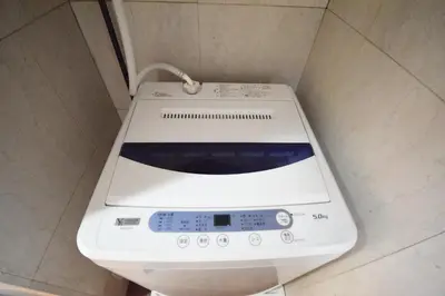 a washing machine sitting on top of a toilet in a bathroom at 3 min to Komagome Sta by foot, 15-minute to Shinju, Tokyo station by JR in Tokyo