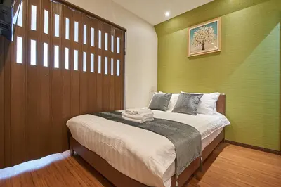 a bedroom with a bed with a green wall at 3 min to Komagome Sta by foot, 15-minute to Shinju, Tokyo station by JR in Tokyo