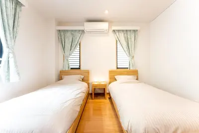 two beds in a room with two windows at Minami-Aoyama-1st in Tokyo