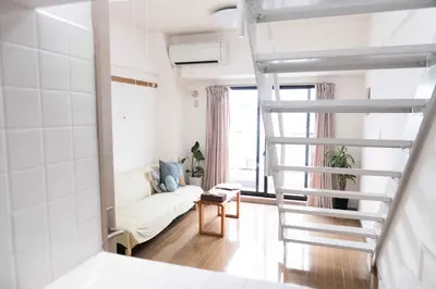 a ladder leading to a living room with a couch at MINIMAL SHIMOKITA Stylish Loft or Studio Apt in Tokyo