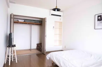 a bedroom with a bed and a sliding door at MINIMAL SHIMOKITA Stylish Loft or Studio Apt in Tokyo