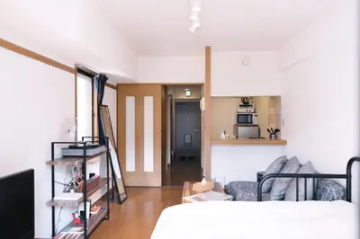 a living room with a bed and a kitchen at MINIMAL SHIMOKITA Stylish Loft or Studio Apt in Tokyo