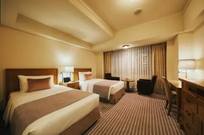 a hotel room with two beds and a desk at Imperial Hotel Tokyo in Tokyo