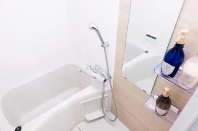 a bathroom with a tub and a shower with a mirror at NEST HATAGAYA Stylish Apt in Tokyo