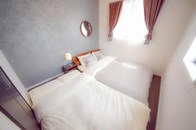 a bedroom with two white beds and a window at FINOA Residential Suite Kagurazaka in Tokyo