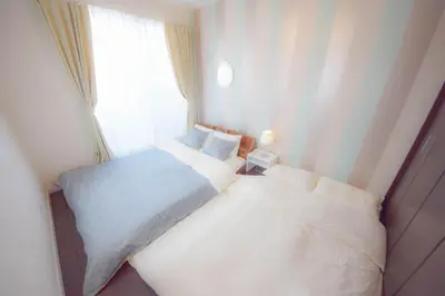 two beds in a small room with a window at FINOA Residential Suite Kagurazaka in Tokyo