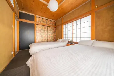 a bedroom with two beds and a window at K&K Jujo House in Tokyo