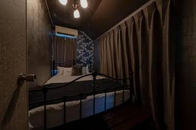 a bedroom with a bed in a room with curtains at K&K Jujo House in Tokyo
