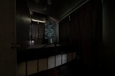 a dark room with a bed and a window at K&K Jujo House in Tokyo