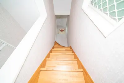 a staircase in a room with white walls and wooden floors at K&K Jujo House in Tokyo
