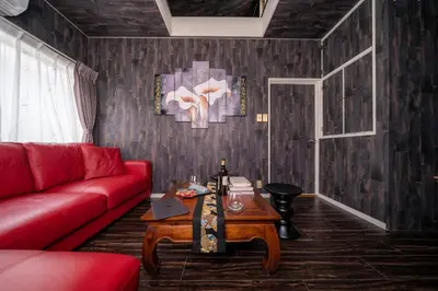 a living room with a red couch and a table at K&K Jujo House in Tokyo