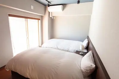 a bedroom with two beds and a window at NIYS apartments 07 type in Tokyo