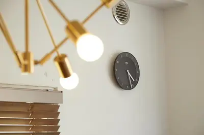 a clock on a wall with a fan and lights at No Service Hotel in Tokyo