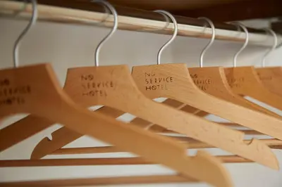 a bunch of wooden spoons hanging on a rack at No Service Hotel in Tokyo