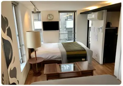 a bedroom with a bed and a table with a clock at world potential / Vacation STAY 4631 in Tokyo