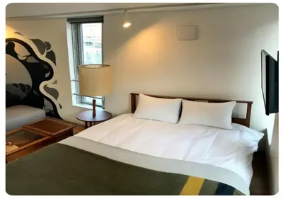 a bedroom with a bed with white sheets and a window at world potential / Vacation STAY 4631 in Tokyo