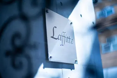 a white sign on the side of a building at Laffitte Tokyo in Tokyo