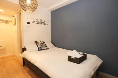 a bedroom with a bed with a wicker basket on it at Tookin house \u6c60\u888b in Tokyo