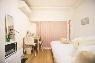 a room with a bed and a table with a television at Tookin house \u6c60\u888b in Tokyo