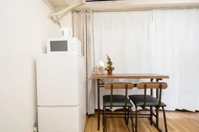 a small kitchen with a table and a refrigerator at Tookin house \u6c60\u888b in Tokyo