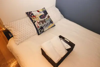 a small bed with a tray of towels on it at Tookin house \u6c60\u888b in Tokyo