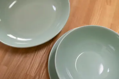two white plates sitting on top of a wooden table at Uhome Akihabara Apartment 3 in Tokyo
