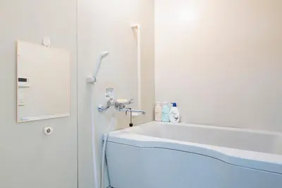 a white bathroom with a sink and a mirror at Uhome Akihabara Apartment 3 in Tokyo