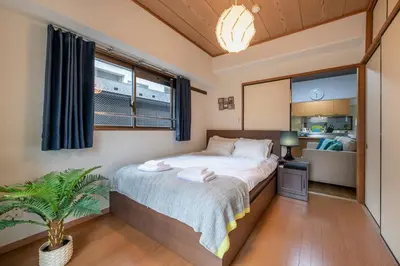 a bedroom with a bed with a plant in it at Uhome Akihabara Apartment 3 in Tokyo