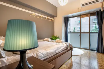 a bedroom with a bed with a green lamp at Uhome Akihabara Apartment 3 in Tokyo