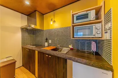 a kitchen with a sink and a microwave at YADOYA Sennokaze in Tokyo