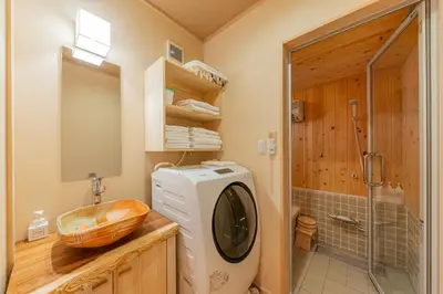 a bathroom with a washing machine and a sink at YADOYA Sennosato in Tokyo