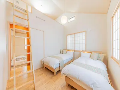 a bedroom with two beds and a ladder at YADOYA Sennosato in Tokyo