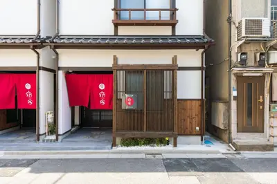 an entrance to a building with red banners on it at YADOYA Sennosato in Tokyo