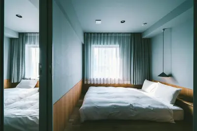 a bedroom with two beds and a window at LANDABOUT TOKYO in Tokyo