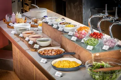 a buffet with many bowls of food on a table at LANDABOUT TOKYO in Tokyo