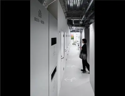 a person walking down a hallway in a building at 9h nine hours Suidobashi in Tokyo